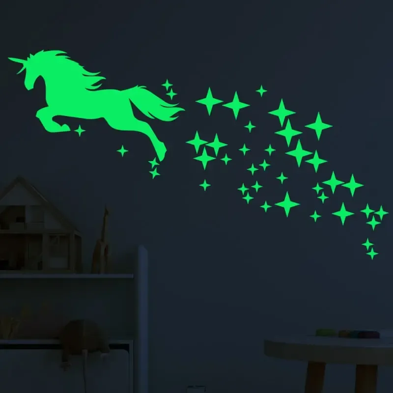 Selvlysende wallsticker med en flyvende Enhjørning omgivet af stjerner. Grøn.